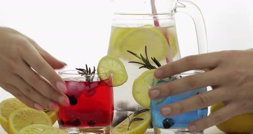 Refreshing Drinks with Lemon and Berries Clinking Together