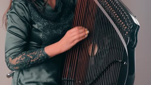 Woman Plays Celtic Harp in Studio Setting
