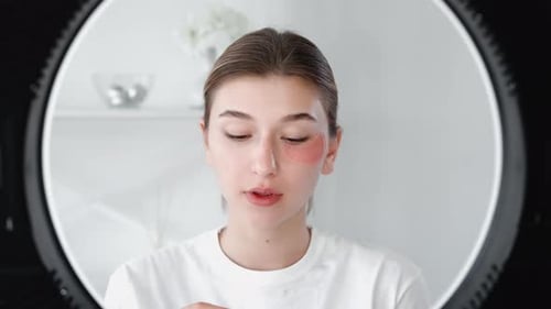 Woman Applies Skincare Eye Patches at Home