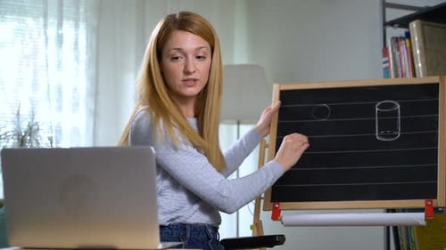 Woman Teaching Online Class with Laptop and Chalkboard