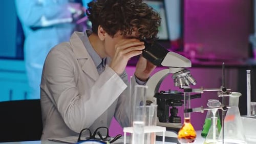 Wissenschaftlerin inspiziert Probe im Mikroskop