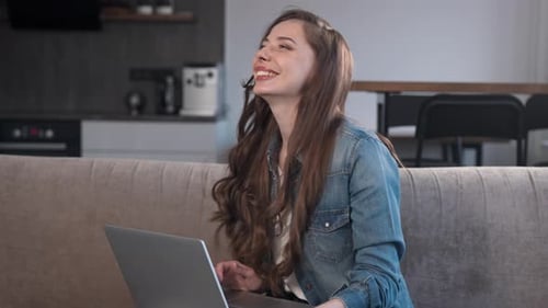 Woman Using Laptop on Couch at Home