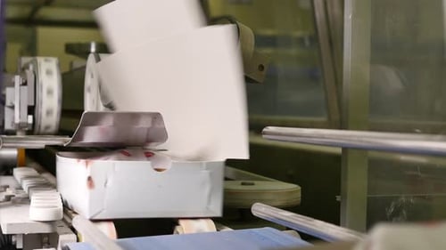 Faltbare weiße Lebensmittelboxen auf einem Förderband in einer Fabrik