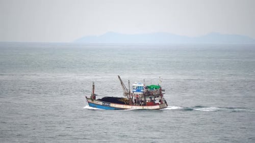Fishing Boat Sails Into the Sea for Seafood on A Cloudy Day