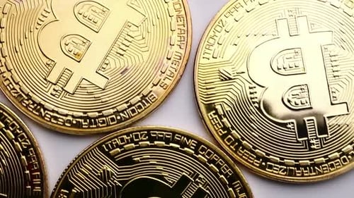 Close up of golden coins with bitcoin symbol background.