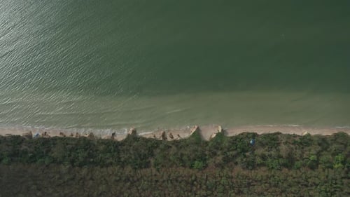 Aerial View of Ocean Waves Beating Against a Rocky Shore on a Sandy Tropical Beach