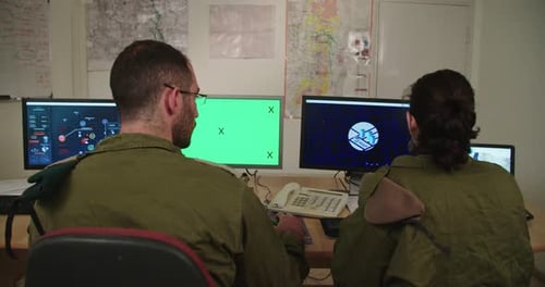 Israeli soldiers in a military command and control room looking at screens