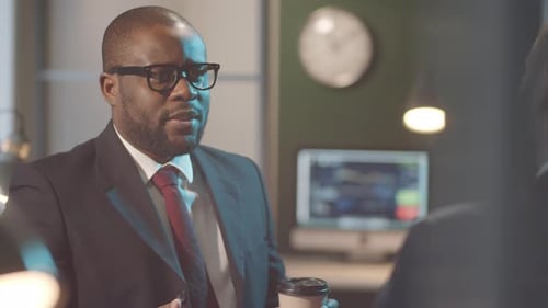 Multiethnic Business Partners Chatting over Coffee in Office