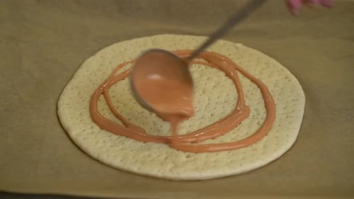 Woman Is Spreading Tomato Sauce on Pizza Dough with Ladle