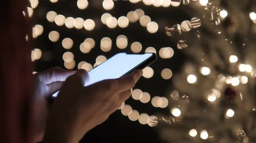Typing Message On Smartphone With Christmas Lights