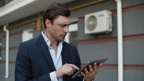Closeup Man Using Tablet Outdoor. Businessman Walking with Touchpad at Street