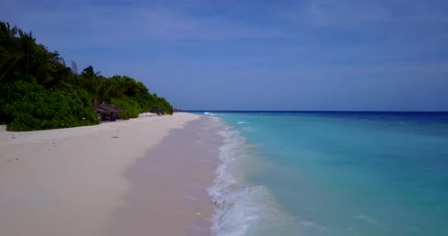 Wide angle above island view of a white paradise beach and turquoise sea background in vibrant 4K