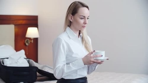 Businesswoman Drinking Coffee in Hotel Room