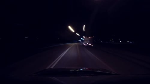 Fast Car Ride Through City at Night in Rays of Street Lights, Long Exposure