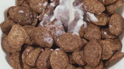 Milk Poured on Chocolate Cereal for Breakfast