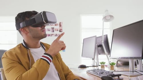 Mixed race man wearing VR headset in creative office