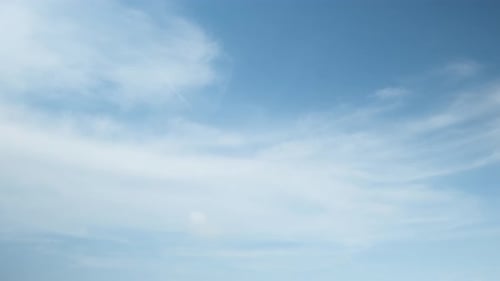 Peaceful Blue Sky with Drifting White Clouds
