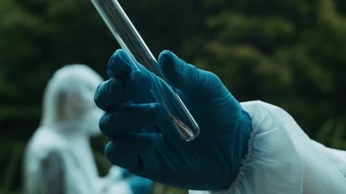 Person Holds Soil Sample in Test Tube