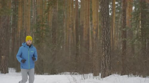Sportsman Running in Forest in Winter