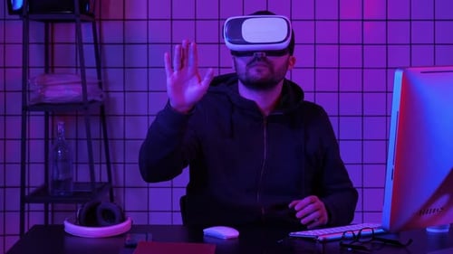 Young Adult Using VR Headset in Neon Lit Room