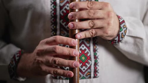Hands of Man spielt auf Holzbläser Holzflöte Ukrainische Sopilka auf dunklem Hintergrund