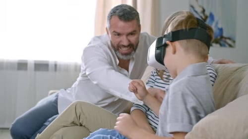 Boy Wearing VR Headset with Family on Couch