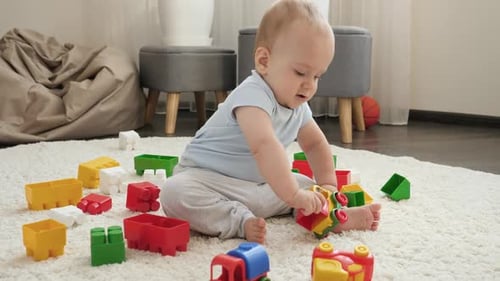 Cute Infant Playing with Toy Cars and Blocks