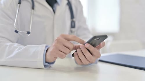 Health Professional Uses Smartphone at Desk