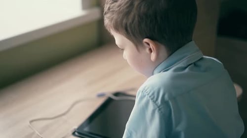 Child Using Tablet Indoors by Window