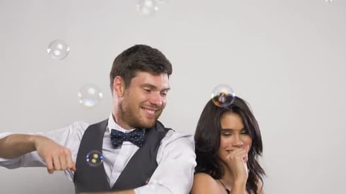 Joyful Couple Celebrating with Soap Bubbles