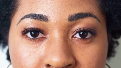 Close-up of African woman's eyes looking into the camera. The face of a black girl. 4K.