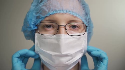 Healthcare Worker Adjusts Protective Medical Mask