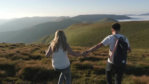 Couple running down a hill
