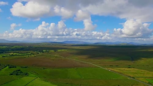 Vehicle moving on road passing through green fields 4k
