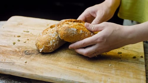 The Woman Demonstrates in Her Hands Two Freshly Baked Bread Sticks