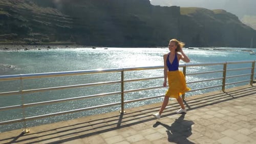 Woman Runs and Twirls on a Pier