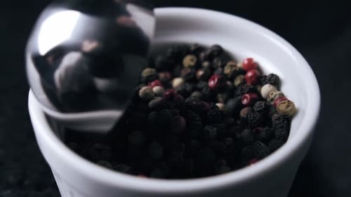 Scooping Some Black Pepper Out of the Bowl Close Up