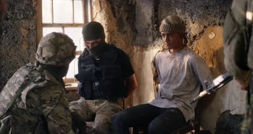 Male Soldier Interrogating Young Prisoners