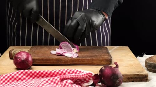 Chef Slicing a Red Onion With Knife