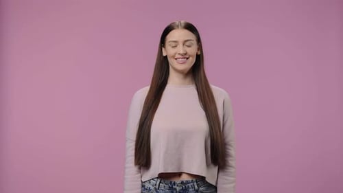 Smiling Woman in Crop Top Against Pink Backdrop