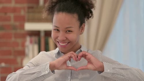 Smiling Woman Making Heart Shape with Hands