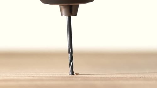 Drill Bit Drilling Into a Wooden Surface