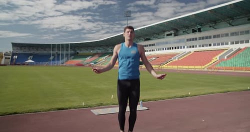 Man Jumping Rope in Stadium on Sunny Day