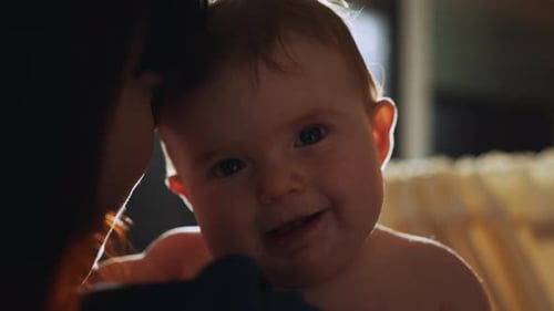 Woman Holds Adorable Baby Close Indoors