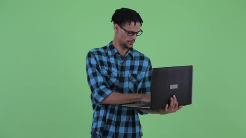 Young Adult Smiling and Typing on Laptop