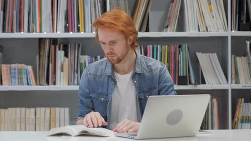 Redhead Man Reading Book, Sitting in Library