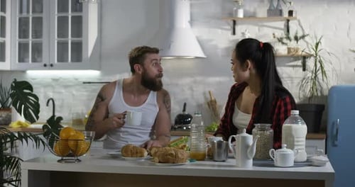 Couple Drinking Coffee and Eating Breakfast Together at Home