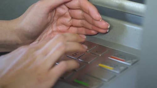 Hands Enter Pin Code Into ATM