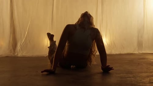 Silhouette of a Professional Dancer Performing in Studio in Soft Warm Lighting