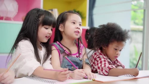 Multiethnische Jungen und Mädchen lernen und spielen in der Grundschule gerne lustig und spielen Malen auf Papier.